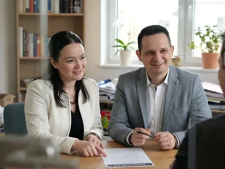 Egzona und Dritero Xhemshiti von IMMO DEX am Schreibtisch mit Verkaufsunterlagen